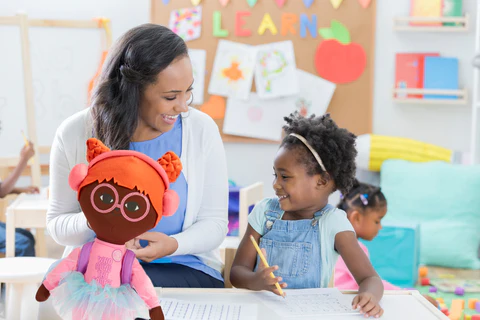 teacher and child playing with doll